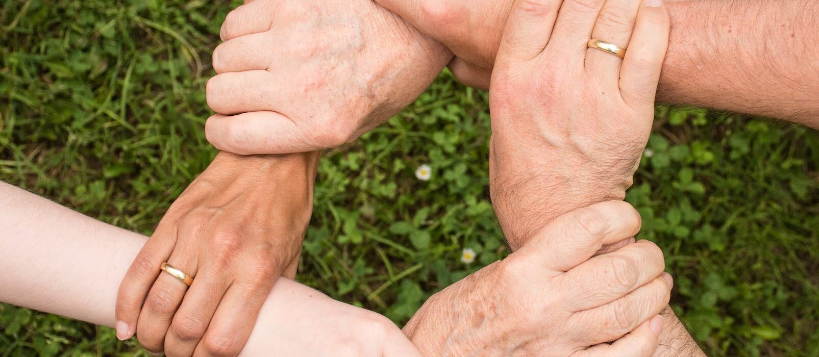 group of people holding arms